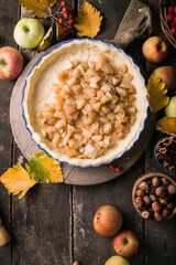 Baking background with raw traditional classic apple pie, bake  ingredients and utensils. Homemade  cake surrounded by fresh fruits