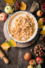 Baking background with raw traditional classic apple pie, bake  ingredients and utensils. Homemade  cake surrounded by fresh fruits