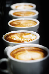 Cup of coffee. Latte art made by barista focus in milk and coffee. Vintage color