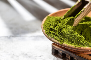 Green powder chlorella, spirulina on gray concrete background. Concept dieting, detox, healthy superfood, which contains protein.