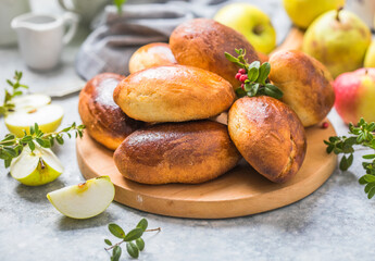 Ready-made baked pies (pirogi) with apple. Traditional russian cuisine.