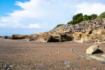 Vend&eacute;e, FRANCE, green and brown and yellow rocks resembling camouflage on a beach in the town of Bretignolles Sur Mer.