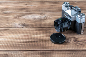 Old retro camera on a wooden background. Close up. Selective focus.