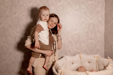 Young blonde mom holding her newborn daughter lying in the bedroom at home
