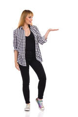 Happy Young Woman Is Standing With Hand Raised And Presenting.