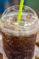 aerated soft drink with ice in plastic glass