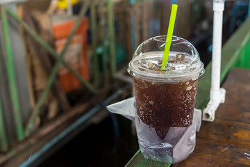 aerated soft drink with ice in plastic glass