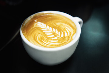 Cup of coffee. Latte art made by barista focus in milk and coffee. Vintage color