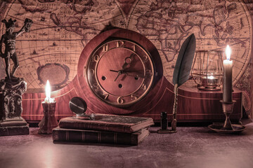 still life wind-up clock and antique books on a vintage world map