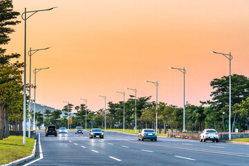 Cars driving on the city road at dawn