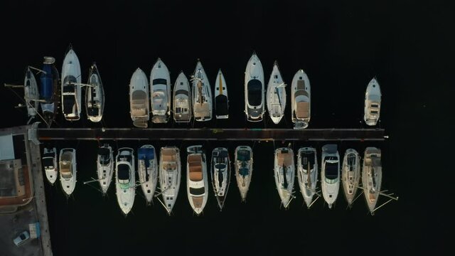 Birds Eye View of Sailboats in Harbour with black water background, Aerial Top Down View