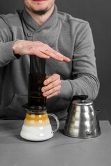 Faceless man of the barista brews coffee by a special method of filtration.
