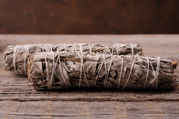 Two white sage smudge sticks on the wooden old background.