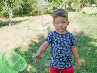 Little explorer with a butterfly net in his hands.