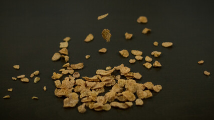 Cereales para el desayuno, en movimiento esparcidos  con fondo oscuro