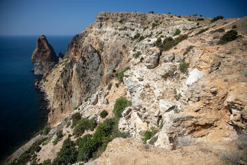 Mountain in the form of a dolphin on the black sea in Crimea. Cape Kapchik in the Black Sea near the village of Novy Svet sunny summer day. Natural colors and light, summer nature background concept.