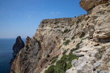 Mountain in the form of a dolphin on the black sea in Crimea. Cape Kapchik in the Black Sea near the village of Novy Svet sunny summer day. Natural colors and light, summer nature background concept.