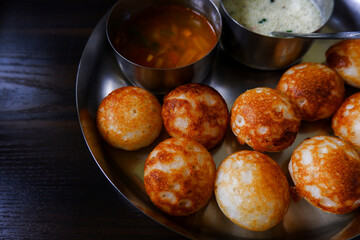 close view of traditional south Indian paddu (rice appe) isolated in plate on wooden table