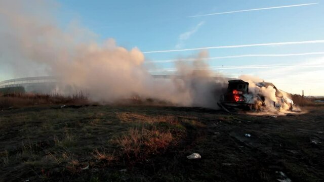 The car is burning in the field. High quality FullHD footage. Hand-held shooting