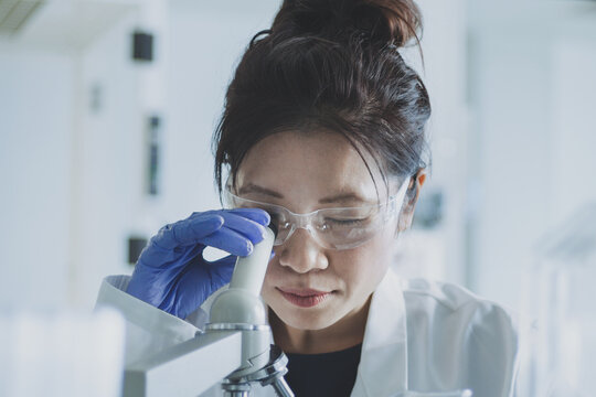 Female scientist looking at microscope