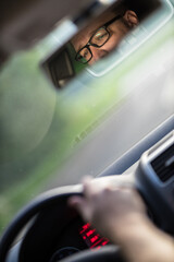 Handsome young driver driving hic car fast yet safely on the road