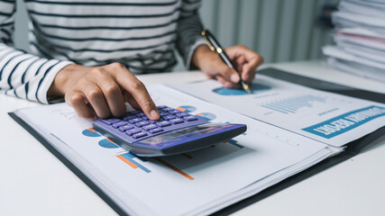 Close up business woman secretary using calculator to do math finance in office with tax accounting statistics research concept.