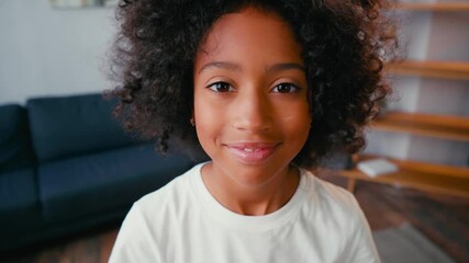 Selective focus of african american girl smiling and looking at camera at home - Powered by Adobe