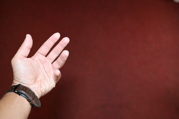 Verschiedene emotionale Zeichen mit der linken Männerhand vor einem dunkelroten Hintergrund, die etwa Angst, Wut, oder Freundschaft symbolisieren.