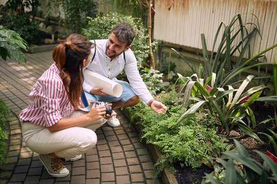 Young couple taking photos of plants