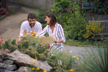 Young male visitor studies a botanical garden map with a young female guide