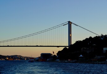 Cruise liner on the Bosporus. Panorama of Istanbul from the Bosphorus. Silouete oh the famous bridge on the Bosphorus side. Panoramic view at a beautiful sunset