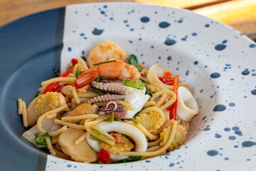 Spicy Seafood Spaghetti Dinner Dish on a the table. Traditional Spicy Spaghetti seafood with Chili & Basil. Seafood pasta Spaghetti with Clams, Prawns and Squid.