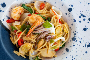 Spicy Seafood Spaghetti Dinner Dish on a the table. Traditional Spicy Spaghetti seafood with Chili & Basil. Seafood pasta Spaghetti with Clams, Prawns and Squid.