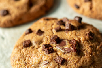 Homemade cookies on cooling tray. Cookies with chocolate on dark wooden background. Homemade Chocolate chip cookies.