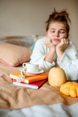 Obraz na płótnie Canvas Sad teen girl dreaming, bored, hot coffee in bed.Cozy autumn