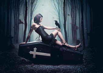 Femme gothique sur cercueil dans une forêt sombre avec un corbeau, halloween