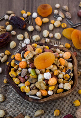 Mixed,crispy, dry nuts in a wooden plate on wooden table,with dried fruits,rustic design