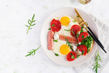 English breakfast - fried eggs, sausages, tomatoes and feta cheese. American food. Top view, overhead, copy space