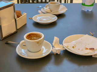 empty drunk cup of coffee and eaten cake on the table of the cafe close-up. Coffee break concept. 