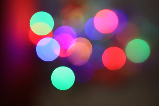 Die bunten und verschwommenen Lichter eines kleinen und wei&szlig;en Weihnachtsbaumes stehend auf einem roten Tuch.