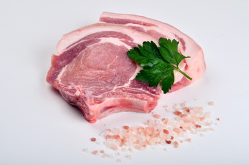 Sliced raw pork steak isolated on white background. Top view. Sliced raw pork steak with green perslay and pink salt