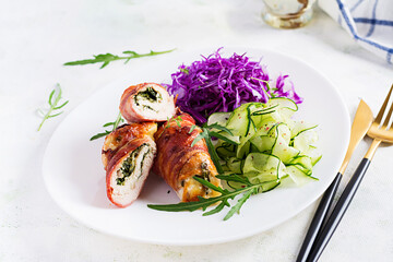 Ketogenic diet. Dinner dish with chicken meat roll wish  bacon and salad wich red cabbage, cucumber, arugula. Detox and healthy concept. Keto food.