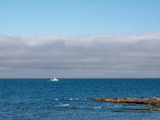 Fishing boat heading out to the ocean in the early morning