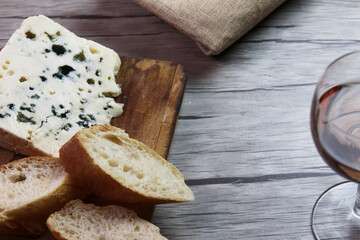 Queso Roquefort con trozos de pan sobre tabla de picar