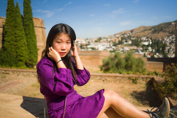 lifestyle portrait of young beautiful and happy Asian Korean tourist woman having Summer holidays in Europe enjoying cheerful visiting beautiful Alhambra of Granada in Spain