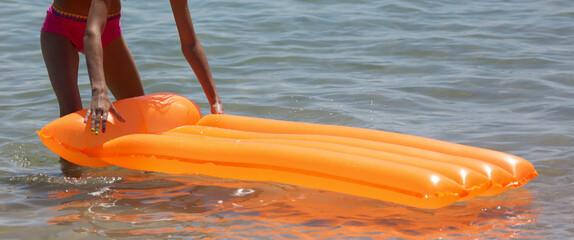 The girl swims with an inflatable mattress