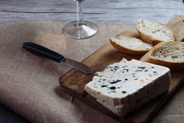 Queso Roquefort con trozos de pan sobre tabla de picar