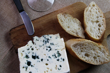 Queso Roquefort con trozos de pan sobre tabla de picar