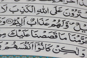 Closeup of Holy Quran script or text in arabic calligraphy.