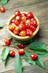 Fresh sweet cherries with leaves in a wooden plate